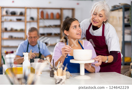 Potter woman in workshop gives modeling lesson Potter woman in workshop gives modeling lesson 124642229