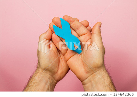 Supporting cancer awareness with blue ribbon held in hands for health hope 124642366