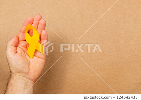 Support and awareness for cancer detection with a yellow ribbon Support and awareness for cancer detection with a yellow ribbon 124642433