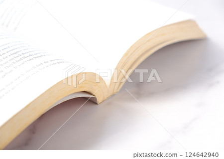 An image of someone opening an English paperback and enjoying a leisurely read An image of someone opening an English paperback and enjoying a leisurely read 124642940