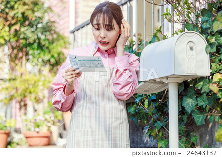 Woman surprised at meter reading chart: electricity, gas, water bills Woman surprised at meter reading chart: electricity, gas, water bills 124643132