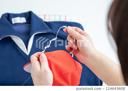 The elastic band of the red and white hat has stretched out 124643608