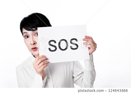 A middle-aged woman holding up a card that says SOS 124643866