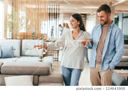 Walking around. Couple choosing the sofa and bed in the store 124643908
