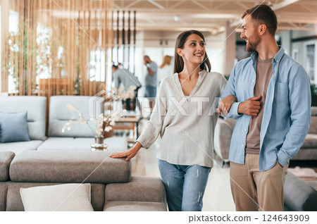 Walking around. Couple choosing the sofa and bed in the store 124643909