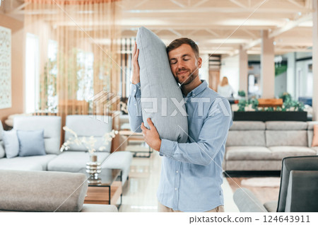 Embracing the pillow. Customer visiting the sofa and bed store. Looking for update Embracing the pillow. Customer visiting the sofa and bed store. Looking for update 124643911