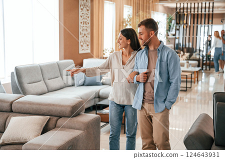 Beautiful product. Couple choosing the sofa and bed in the store Beautiful product. Couple choosing the sofa and bed in the store 124643931