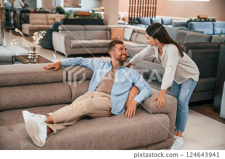 Having fun. Couple choosing the sofa and bed in the store 124643941