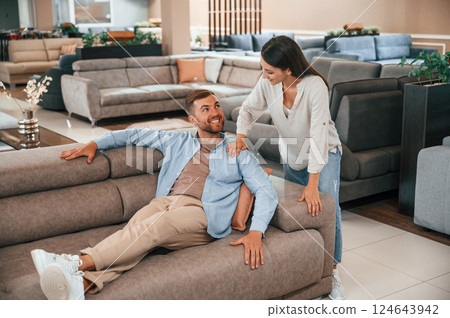 Having fun. Couple choosing the sofa and bed in the store 124643942