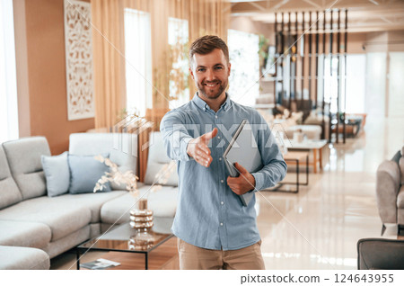 Friendly consultant is happy to see you in the sofa store Friendly consultant is happy to see you in the sofa store 124643955