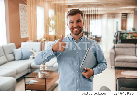 Friendly consultant is happy to see you in the sofa store Friendly consultant is happy to see you in the sofa store 124643956