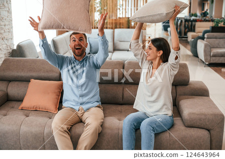 Happy couple choosing the sofa and bed in the store 124643964