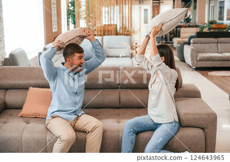 Happy couple choosing the sofa and bed in the store Happy couple choosing the sofa and bed in the store 124643965