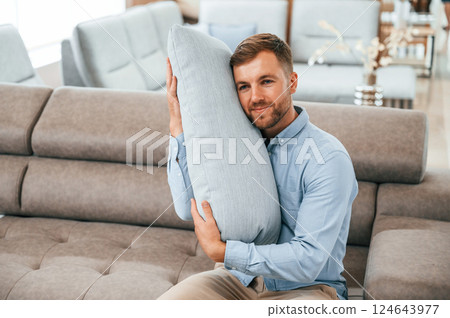 Embracing the pillow. Customer visiting the sofa and bed store. Looking for update 124643977