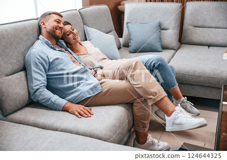 Couple choosing the sofa and bed in the store Couple choosing the sofa and bed in the store 124644325