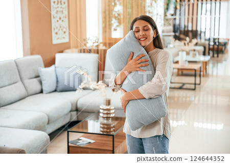 Embracing the pillow. Woman is visiting bed store. Looking for comfortable sofa 124644352