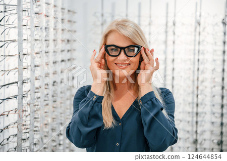 Wearing the glasses. Woman is in the store 124644854