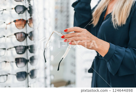 Close up view of the woman that trying new glasses in the store 124644898