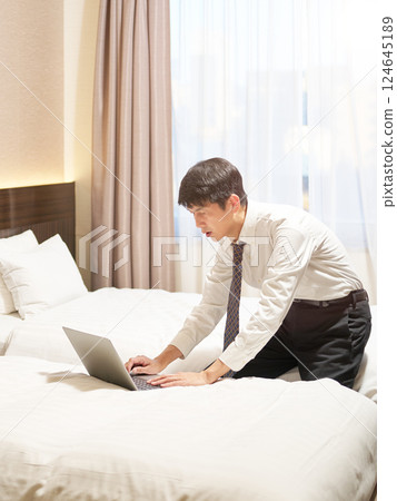 A businessman working in a hotel on a business trip 124645189