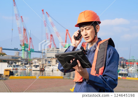 一名碼頭工人在用平板電腦聊天 124645198