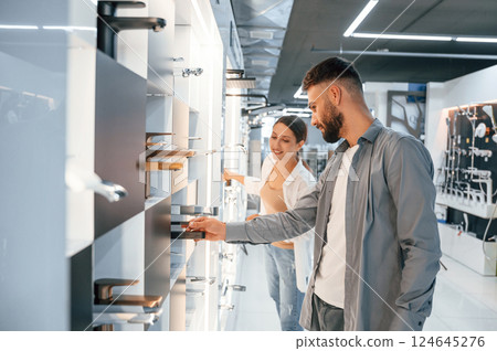 Bath cranes. Woman and man is in the store of goods for the home Bath cranes. Woman and man is in the store of goods for the home 124645276