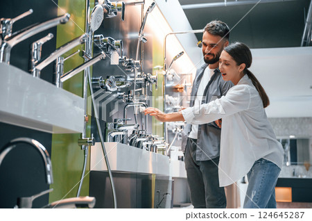 Fun couple looking for products. Woman and man is in the store of goods for the home Fun couple looking for products. Woman and man is in the store of goods for the home 124645287