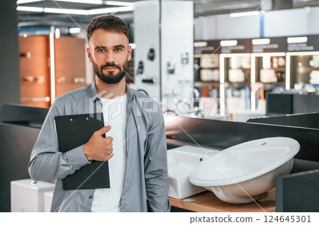 Manager with notepad. Stylish beautiul man is in the store of goods for the home Manager with notepad. Stylish beautiul man is in the store of goods for the home 124645301