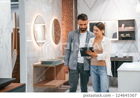 Helping choose right product. Woman and man is in the store of goods for the home 124645307