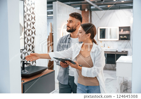 Helping choose right product. Woman and man is in the store of goods for the home 124645308