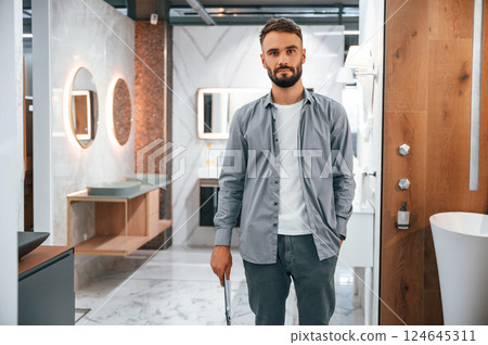 Manager with notepad. Stylish beautiul man is in the store of goods for the home Manager with notepad. Stylish beautiul man is in the store of goods for the home 124645311