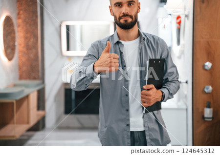 Manager with notepad. Stylish beautiul man is in the store of goods for the home 124645312