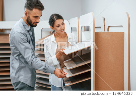 Quality wood. Woman and man is in the store of goods for the home Quality wood. Woman and man is in the store of goods for the home 124645323