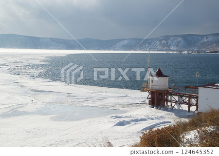 Scenic at the ice-free Angara River flows out of the frozen Lake Baikal. Melted ice floes on blue water.  Located Baikal lake. 124645352