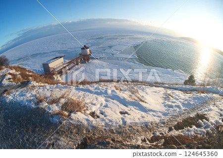 Scenic at the ice-free Angara River flows out of the frozen Lake Baikal. Melted ice floes on blue water. Located Baikal lake. Scenic at the ice-free Angara River flows out of the frozen Lake Baikal. Melted ice floes on blue water. Located Baikal lake. 124645360