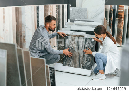 Indoors together. Woman and man is in the store of goods for the home Indoors together. Woman and man is in the store of goods for the home 124645629