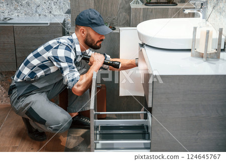 Plumber in uniform is working indoors 124645767