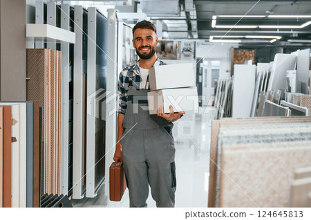 With equipment. Stylish beautiul man is in the store of goods for the home 124645813
