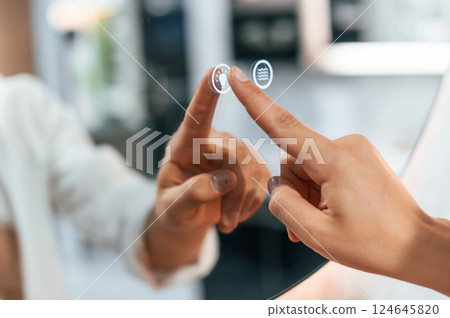 Using the mirror with touchscreen feature. Pretty young woman is in the store of goods for the home 124645820