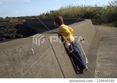 <People> A woman walking along the seaside (along the embankment) <People> A woman walking along the seaside (along the embankment) 124646389