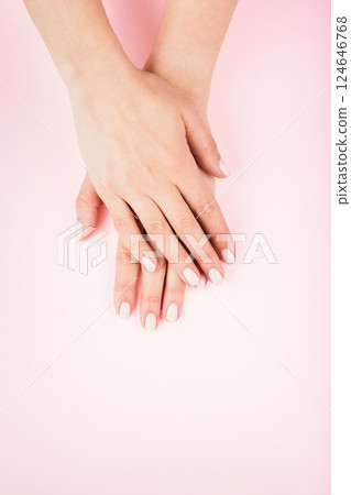 Female's hands with classic pastel manicure on pink background. Beauty salon. Female's hands with classic pastel manicure on pink background. Beauty salon. 124646768