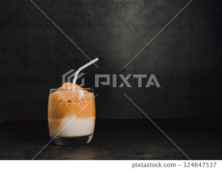 Iced or frappe coffee smoothie on a glass cup on black marble backdrop 124647537