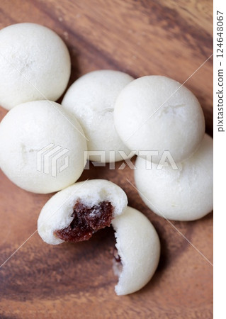 Cross-section of a bite-sized bun filled with bean paste, split in half 124648067