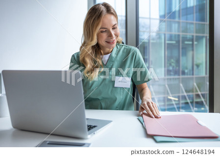 Woman medical specialist in clinic using computer analyzing patient case histories Woman medical specialist in clinic using computer analyzing patient case histories 124648194