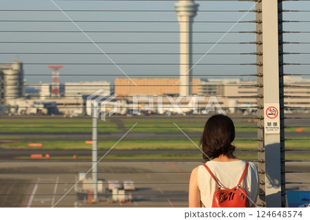 A woman looking at the runway from Terminal 3. The back view of a woman looking at the runway from the observation deck at Haneda Airport. A woman looking at the runway from Terminal 3. The back view of a woman looking at the runway from the observation deck at Haneda Airport. 124648574