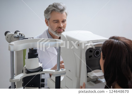 Male specialist checking female vision in ophthalmology clinic Male specialist checking female vision in ophthalmology clinic 124648670