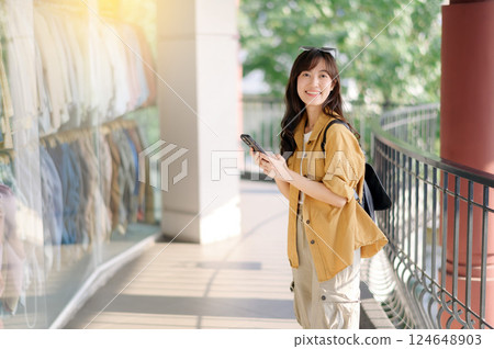 Traveler young asian woman 30s using smartphone while exploring urban street in Bangkok, Thailand. 124648903