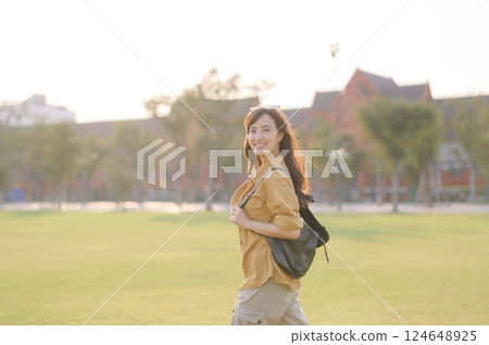 Traveler asian woman in her 30s stands bathed in the golden glow of sunset, embracing the freedom of exploration. on summer holiday weekend vacation trip in Bangkok, Thailand 124648925