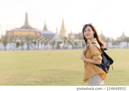 A Traveler Asian woman in her 30s exploring Wat Pra Kaew. From stunning architecture to friendly locals, she cherishes every moment, capturing it all in her heart and camera for years to come. 124648932