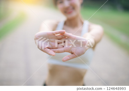 Female runner. Fit young Asian woman with sportswear stretching muscle in park before running and enjoying healthy outdoor. Fitness runner girl in public park. Wellness being concept Female runner. Fit young Asian woman with sportswear stretching muscle in park before running and enjoying healthy outdoor. Fitness runner girl in public park. Wellness being concept 124648993