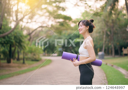 pretty fitness yoga woman in the park with yoga mat 124648997